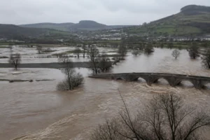 Rivière en crue hivernale débordant sur des prairies dans une vallée française