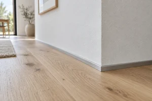 Profilé aluminium discret en alternative aux plinthes entre parquet flottant et mur blanc